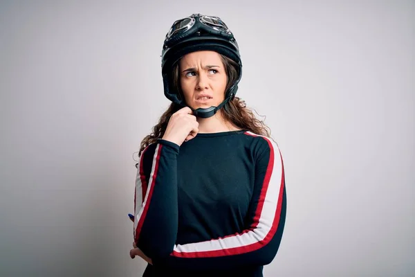 巻き毛の美しいバイク乗りの女性は 顎の質問について考える上で手で白い背景に元ヘルメットを身に着けています 思慮深い顔で微笑んだ 疑いの概念 — ストック写真