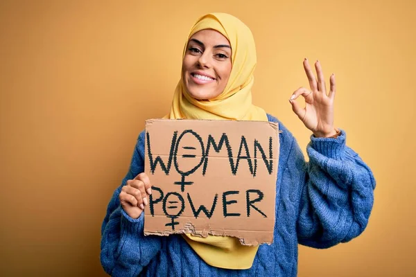 若い美しいアラブ女性を身に着けていますイスラムヒジャーブ保持バナーで女性のパワーメッセージとOkサインを行う指で 優れたシンボル — ストック写真