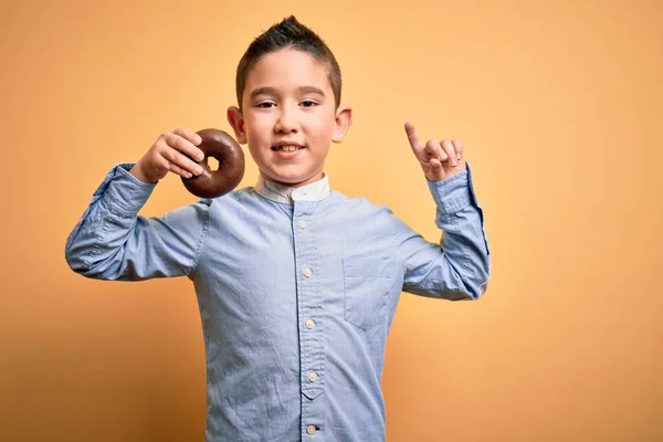 Маленький Мальчик Ребенок Ест Нездоровый Шоколадный Пончик Изолированном Желтом Фоне — стоковое фото