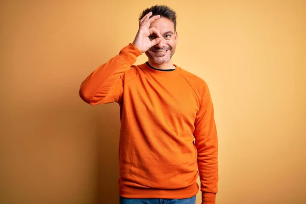 Joven Hombre Guapo Usando Suéter Casual Naranja Pie Sobre Fondo — Foto de Stock