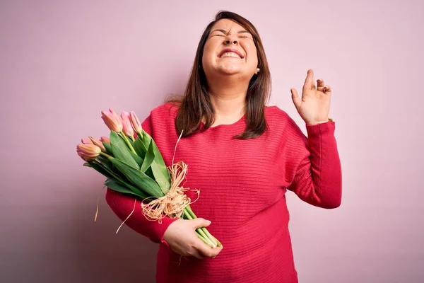 Güzel Cüsseli Bir Kadın Pembe Arka Planda Çiçek Buketi Tutuyor — Stok fotoğraf