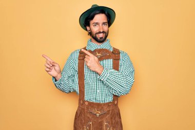 Almanya Festivali için geleneksel Alman Ekim Festivali kıyafeti giyen genç yakışıklı adam gülümsüyor ve kameraya bakıyor..