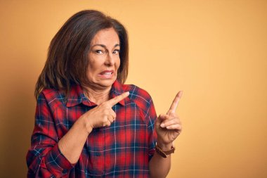 Orta yaşlı, güzel bir kadın, sıradan bir gömlek giymiş, sarı arka planda dikiliyor. Endişeli ve gergin bir tarafı var, endişeli ve şaşırmış bir ifadeyle.