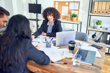 İpotek başvurusunda bulunan genç ve güzel bir çift. Mutlu bir şekilde oturmuş, emlakçıyla banka kredisini imzalıyor.