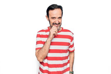 Orta yaşlı, çizgili tişört giyen yakışıklı bir adam izole edilmiş beyaz arka planda dikiliyor kameraya kollarını kavuşturup çenesi üzerinde kendinden emin bir şekilde bakıyor. Olumlu düşünüyorum..