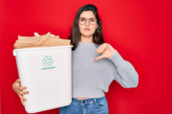 リサイクル段ボール容器を持っている若い美しい女性は 怒りの顔を持つ環境のためのリサイクル 親指ダウンで嫌いを示す負の記号 拒否の概念 — ストック写真