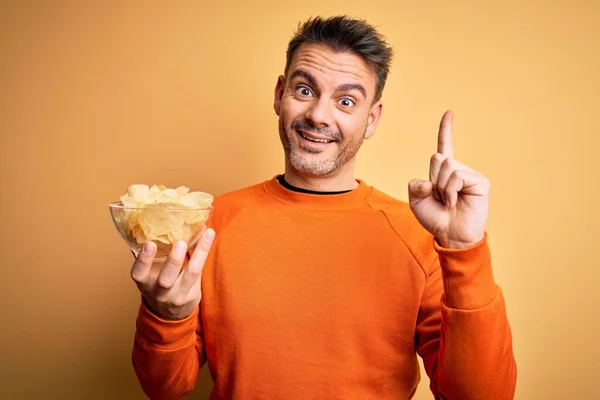 Joven Hombre Guapo Sosteniendo Tazón Con Papas Fritas Sobre Fondo — Foto de Stock