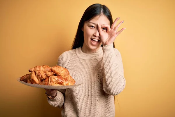 Joven Asiática Mujer Sosteniendo Francés Pastelería Croissant Sobre Amarillo Aislado — Foto de Stock