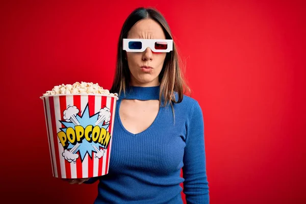 若いブロンドの女性は3Dメガネを着用し 問題のために動揺を眉をひそめて 映画の懐疑的で緊張した映画を見てポップコーンのパックを食べています 負の人 — ストック写真