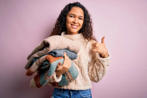 Hermosa Mujer Tendero Con Pelo Rizado Sosteniendo Pila Ropa Sobre — Foto de Stock