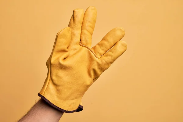 Hand Eines Kaukasischen Jungen Mannes Mit Gärtnerhandschuh Über Isoliertem Gelbem — Stockfoto