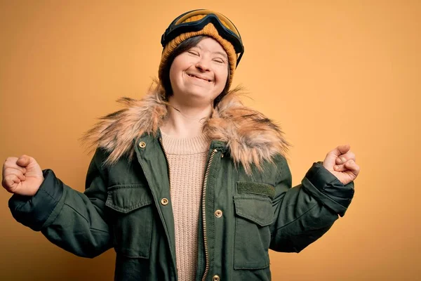 年轻的下意识的女人穿着滑雪外套 戴着眼镜过冬 非常高兴而兴奋地举起双臂做获奖者的手势 微笑着 尖叫着要成功 庆祝概念 — 图库照片