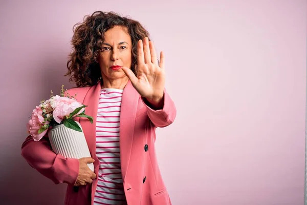 Middle Age Beautiful Woman Holding Vase Flowers Isolated Pink Background — Φωτογραφία Αρχείου