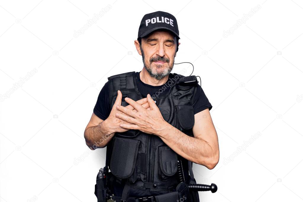 Middle age policeman wearing police uniform and bulletproof vest over white background smiling with hands on chest, eyes closed with grateful gesture on face. Health concept.