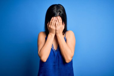 Zarif ve rahat mavi iç çamaşırı giyen genç, güzel esmer kadın. Ağlarken suratını ellerle kapatan üzgün bir ifade. Depresyon kavramı.