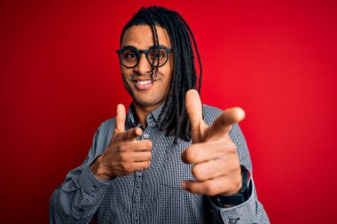 Rastgele gömlek ve gözlük takmış, neşeli ve komik yüzüyle kamerayı işaret eden Afro-Amerikan genç yakışıklı adam. İyi enerji ve titreşimler.