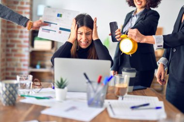 Group of business workers working together. Partners stressing one of them at the office