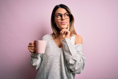 Genç, güzel esmer, gözlüklü, pembe kahve fincanı içen, ciddi yüzlü soru soran, kafası karışık bir kadın.