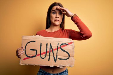 Genç, güzel bir aktivist kadın elinde durdurucu silahlarla barış pankartı istiyor. Elleri havada, utanç ve şaşkınlık dolu, sinirli ve hayal kırıklığına uğramış bir şekilde. Hata için korku ve üzüntü.