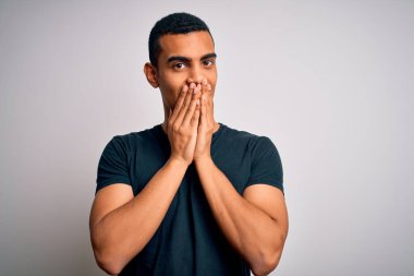 Beyaz arka planda dikilen gündelik tişört giyen genç ve yakışıklı Afro-Amerikalı adam gülüyor ve utanıyor. Ağzı ellerle, dedikoduyla ve skandal konseptiyle örtüyor.