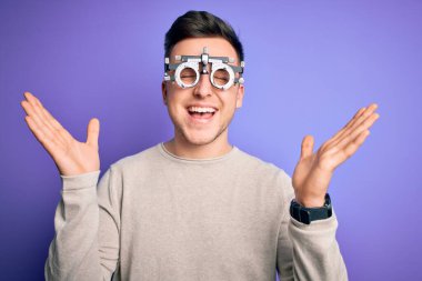 Mor arka planda optometrik gözlük takan yakışıklı beyaz adam başarı için deli ve çılgınlığı kutluyor kollarını kaldırmış ve gözlerini kapamış heyecanla haykırıyor. Kazanan konsept
