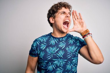 Sarışın, tatilde, kıvırcık saçlı, sıradan bir tişört giyen, el ele tutuşup bağıran genç, yakışıklı bir adam. İletişim konsepti.