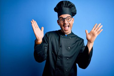 Genç, yakışıklı aşçı üniforması ve şapkalı bir adam deliliği kutluyor ve kollarını kaldırıp heyecanla haykırarak başarıyı kutluyor. Kazanan konsept