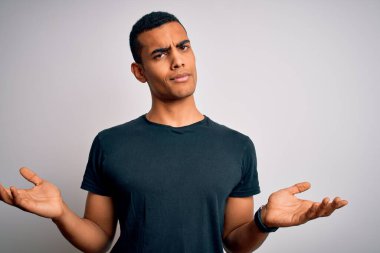 Genç, yakışıklı, Afro-Amerikan bir adam. Sıradan tişörtler giyiyor. Beyaz arka planda duruyor..