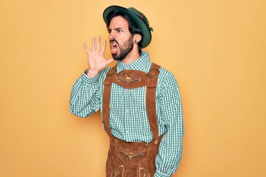 Almanya festivali için geleneksel Alman Ekim Festivali kıyafeti giyen genç yakışıklı adam el ele tutuşarak bağırıyor ve çığlık çığlığa bağırıyordu. İletişim konsepti.