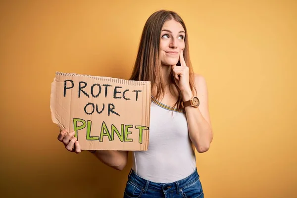 若い赤毛の女性は地球のメッセージを保護するためのバナーを保持する環境を求めて質問について真剣に考えて 非常に混乱したアイデア — ストック写真
