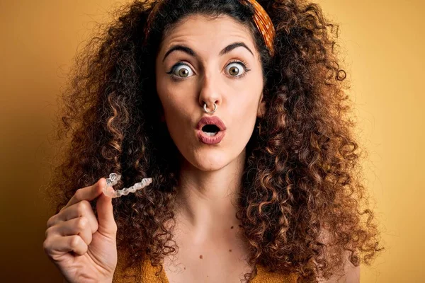 Kıvırcık Saçlı Piercingli Genç Bir Kadın Diş Hizalama Aleti Tutuyor — Stok fotoğraf