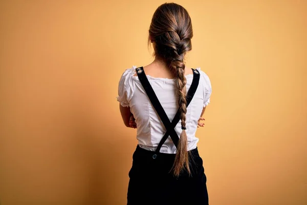 年轻美丽的黑发德国女人穿着传统服装站在后面 两臂交叉地将目光移开 庆祝十月节 — 图库照片