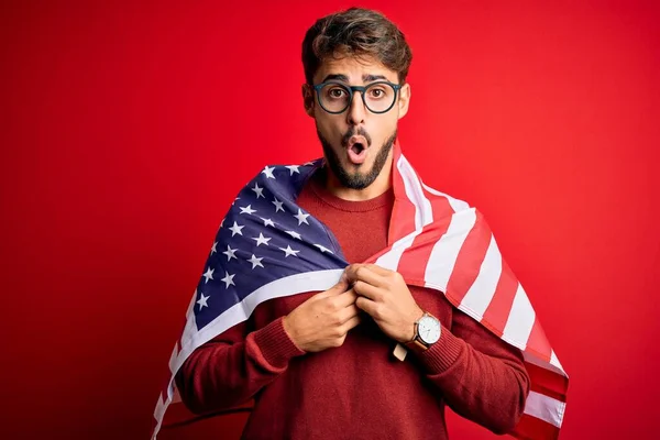 Ung Man Bär Glasögon Och Usa Flagga Över Isolerad Röd — Stockfoto
