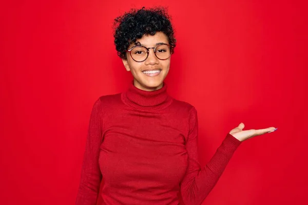 Fiatal Gyönyörű Afro Amerikai Garbó Pulóvert Szemüveget Visel Vidám Bemutató — Stock Fotó