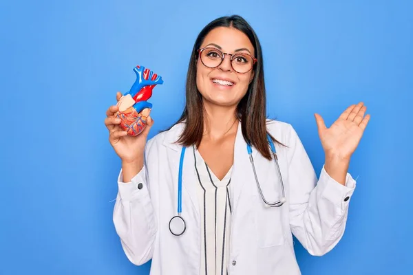 Young Beautiful Brunette Cardiologist Woman Wearing Stethoscope Holding Plastic Heart — Stock Photo, Image