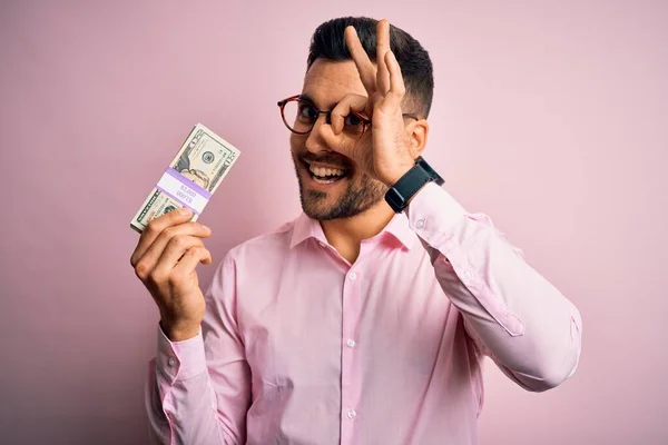 Młody Biznesmen Trzymając Kilka Dolarów Banknotów Różowym Tle Odizolowany Szczęśliwy — Zdjęcie stockowe