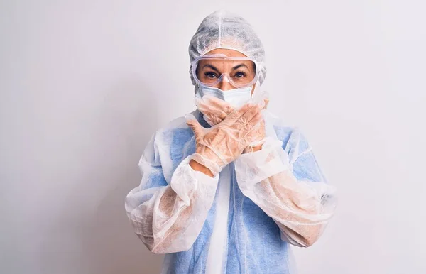 白い背景の上に保護コロナウイルス装置を身に着けている中年の看護師の女性は間違いのための手で口を覆うショックを受けた 秘密概念 — ストック写真