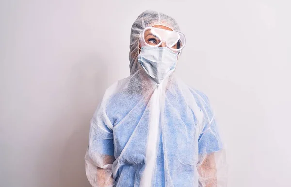 中年看護師の女性身に着けています保護コロナウイルス装置上の白い背景笑顔側を見て 離れて考えて見つめて — ストック写真