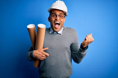 Genç Afro-Amerikan Afro-Amerikan mimar güvenlik kaskı takmış elinde gururla bağıran, zaferi ve başarıyı kutlayan, heyecanlı, neşeli duygular besleyen planlar taşıyor.