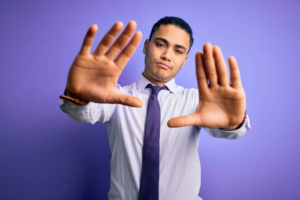 年轻的巴西商人 戴着雅致的领带 站在孤立的紫色背景上 用手心和手指头 镜头透视画框 — 图库照片