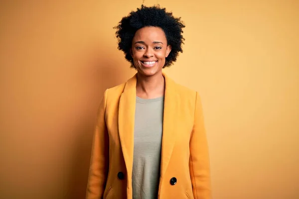 顔に幸せとクールな笑顔で黄色のジャケットを着て巻き毛を持つ若い美しいアフリカ系アメリカ人アフロビジネス女性 運のいい人 — ストック写真