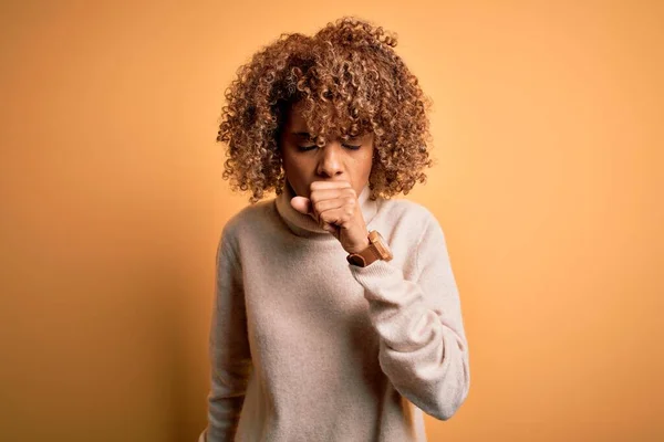 黄色の背景感にタートルネックセーターを着た若い美しいアフリカ系アメリカ人女性が体調を崩し 風邪や気管支炎の症状として咳をしています ヘルスケアの概念 — ストック写真