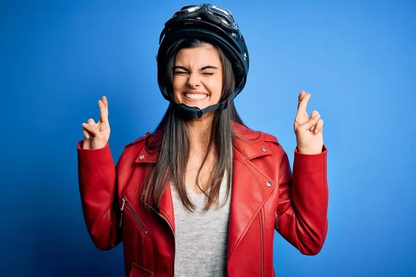 年轻美丽的黑发摩托车手女人 戴着摩托车头盔 穿着夹克衫 摆弄着姿势 微笑着与希望交汇 闭上了双眼 运气和迷信观念 — 图库照片