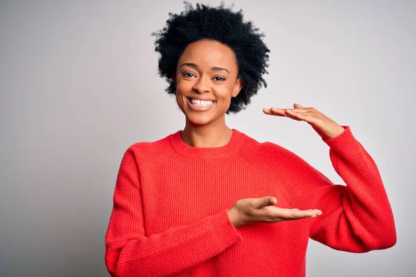 手でジェスチャーを赤いカジュアルなセーターを着て巻き毛を持つ若い美しいアフリカ系アメリカ人アフロ女性は 大小のサインを示す 指標シンボル カメラを見て微笑んだ 概念の測定 — ストック写真