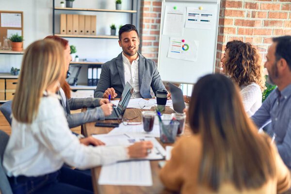 Группа бизнес-работников, работающих вместе. Сидя на столе с помощью ноутбука чтение документов в офисе