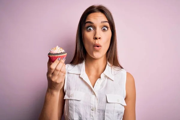 Genç Güzel Esmer Kadın Pembe Arka Planda Çikolatalı Kek Yiyor — Stok fotoğraf