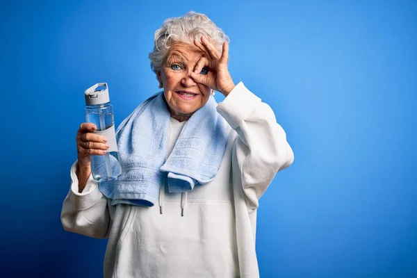 Senior Bela Mulher Desportiva Segurando Garrafa Água Sobre Fundo Azul — Fotografia de Stock