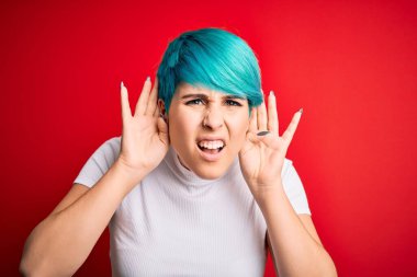 Mavi saçlı, kırmızı arka planda sıradan tişörtler giyen genç ve güzel bir kadın. İki elini de kulak hareketi yaparken duymaya çalışıyor. Dedikoduya meraklı. İşitme problemi, sağır