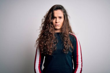 Kıvırcık saçlı genç bir kadın izole edilmiş beyaz arka planda günlük süveter giyiyor. Depresyon geçiriyor ve sıkıntıdan endişe ediyor. Kızgın ve korkmuş. Üzücü ifade.