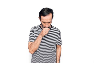 İzole edilmiş beyaz arka plan üzerinde duran çizgili tişört giyen yakışıklı bir adam kendini iyi hissetmiyor ve soğuk algınlığı veya bronşitin belirtisi olarak öksürüyor. Sağlık hizmeti kavramı.